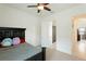 Bedroom with dark wood bed frame, ceiling fan, and open doorway to the hallway at 9769 Highland Park Pl, Palmetto, FL 34221