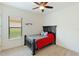 Bedroom with dark wood bed frame, ceiling fan, and window with blinds at 9769 Highland Park Pl, Palmetto, FL 34221