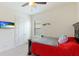 Bedroom with dark wood bed frame, ceiling fan, and television mounted on the wall at 9769 Highland Park Pl, Palmetto, FL 34221