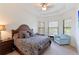 Bright main bedroom features a tray ceiling, ceiling fan, and multiple windows with blinds at 9769 Highland Park Pl, Palmetto, FL 34221