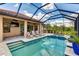 Relaxing screened pool with an attached spa, comfortable lounge chairs, and outdoor television for entertainment at 9769 Highland Park Pl, Palmetto, FL 34221