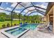 Screened pool area with spa, tiled deck, and lush landscaping offers a relaxing outdoor space at 9769 Highland Park Pl, Palmetto, FL 34221