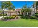 Landscaped front yard with lush greenery and palm trees at 7167 Whitemarsh Cir, Lakewood Ranch, FL 34202