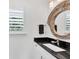 Bathroom with dark countertop and round mirror at 1701 Sandalwood Dr, Sarasota, FL 34231