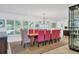 Elegant dining room with a long wooden table and pink chairs at 1701 Sandalwood Dr, Sarasota, FL 34231