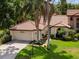 Property view showcasing the home's tile roof and front yard at 7360 Oak Moss Dr # 4, Sarasota, FL 34241