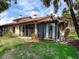 Rear view of home showcasing patio and well-manicured lawn at 7360 Oak Moss Dr # 4, Sarasota, FL 34241