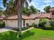 Exterior view of home with attached garage and lush landscaping at 7360 Oak Moss Dr # 4, Sarasota, FL 34241