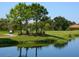 Golf course view with pond, players, and golf cart at 7758 Us Open Loop, Lakewood Ranch, FL 34202