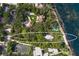 Aerial view of a waterfront lot, next to tennis court, and surrounded by trees at 3301 Bay Shore Rd, Sarasota, FL 34234