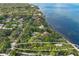 Aerial view of waterfront property with lush landscaping and tennis court at 3301 Bay Shore Rd, Sarasota, FL 34234