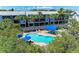 Overhead view of a community pool amidst lush trees near condo buildings, creating a resort-like atmosphere at 3607 E Bay Dr # 202, Holmes Beach, FL 34217