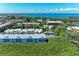 Stunning aerial view showcases a condo complex nestled in a tropical paradise with water features, a pool, and lush landscaping at 3607 E Bay Dr # 202, Holmes Beach, FL 34217