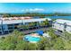 Scenic aerial view of condos with a community pool and lush landscaping, creating an inviting outdoor space at 3607 E Bay Dr # 202, Holmes Beach, FL 34217