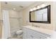 Well-lit bathroom featuring a shower and tub, spacious vanity, and a large mirror at 3607 E Bay Dr # 202, Holmes Beach, FL 34217