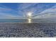 A tranquil beach scene featuring soft sand and gentle waves under a sunny sky, offering a peaceful retreat at 3607 E Bay Dr # 202, Holmes Beach, FL 34217