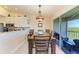 Cozy dining area with stylish light fixture, balcony access, and adjacent kitchen at 3607 E Bay Dr # 202, Holmes Beach, FL 34217