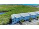 A condo with views, a light gray roof, palm trees, and an open space underneath at 3607 E Bay Dr # 202, Holmes Beach, FL 34217