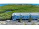 Exterior shot of condo building with covered parking and green foliage behind at 3607 E Bay Dr # 202, Holmes Beach, FL 34217