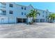 Condo building with garages underneath and palm trees out front at 3607 E Bay Dr # 202, Holmes Beach, FL 34217