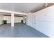 This is a garage with white walls and a gray floor, equipped with two green trash cans, enhancing the functionality of the space at 3607 E Bay Dr # 202, Holmes Beach, FL 34217