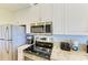 Modern kitchen appliances including stainless steel refrigerator, microwave, stove, and coffee maker at 3607 E Bay Dr # 202, Holmes Beach, FL 34217