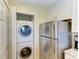Convenient laundry area featuring a stacked washer and dryer next to the refrigerator in the kitchen at 3607 E Bay Dr # 202, Holmes Beach, FL 34217