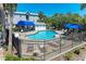 Community pool area with a blue awning, lounge chairs, and a secure fence, perfect for relaxation and recreation at 3607 E Bay Dr # 202, Holmes Beach, FL 34217