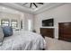 Main bedroom with king bed, dresser, and ensuite bathroom access at 8480 Lindrick Ln, Lakewood Ranch, FL 34202