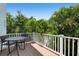 Private deck with table and chairs, overlooking tropical foliage at 4805 2Nd Ave, Holmes Beach, FL 34217