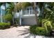 Two-story light blue house with a garage and lush landscaping at 4805 2Nd Ave, Holmes Beach, FL 34217