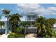 Two-story light blue house with balcony, garage, and tropical landscaping at 4805 2Nd Ave, Holmes Beach, FL 34217