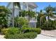 Two-story light blue house with a garage and tropical landscaping at 4805 2Nd Ave, Holmes Beach, FL 34217