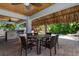 Outdoor patio with table and chairs under a thatched roof near the pool at 4805 2Nd Ave, Holmes Beach, FL 34217