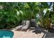 Pool area with lounge chairs and grill, nestled in a tropical garden at 4805 2Nd Ave, Holmes Beach, FL 34217