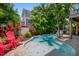 Relaxing kidney-shaped pool with red chairs and lush tropical landscaping at 4805 2Nd Ave, Holmes Beach, FL 34217