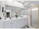 Well-lit bathroom with double sinks, white cabinets, and a glass-enclosed shower at 4714 Elder Berry Dr, Sarasota, FL 34241