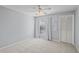 A carpeted bedroom with a ceiling fan, a window with white curtains, and a closet with folding doors at 4714 Elder Berry Dr, Sarasota, FL 34241