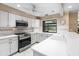 Well-lit kitchen featuring white cabinets, stainless steel appliances, and a view from the window over the sink at 4714 Elder Berry Dr, Sarasota, FL 34241