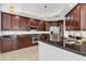 Modern kitchen with dark wood cabinets, stainless steel appliances, and granite countertops at 6438 Watercrest Way # 204, Lakewood Ranch, FL 34202