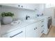 Bright laundry room with white cabinets and quartz countertops at 2430 Floyd St, Sarasota, FL 34239