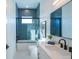 Modern bathroom with blue tile, white vanity, and a glass shower door at 2446 Floyd St, Sarasota, FL 34239