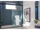 Modern bathroom with blue tile, white vanity, and a glass shower door at 2446 Floyd St, Sarasota, FL 34239
