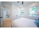 Guest bedroom with a queen bed, light wood floors, and large windows at 2446 Floyd St, Sarasota, FL 34239
