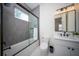 Modern bathroom with gray tile, a bathtub, and a vanity at 2420 Floyd St, Sarasota, FL 34239
