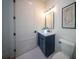 Modern bathroom with navy vanity, white toilet and a frameless glass shower at 2420 Floyd St, Sarasota, FL 34239