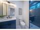 Stylish bathroom featuring a navy blue vanity, hexagon tile shower, and a white toilet at 2420 Floyd St, Sarasota, FL 34239