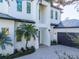 Modern home's exterior features a white facade, dark garage door, and paved driveway at 2420 Floyd St, Sarasota, FL 34239