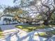 Modern home exterior with a spacious paved driveway and mature oak tree at 2420 Floyd St, Sarasota, FL 34239