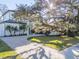 Modern home exterior with a spacious paved driveway and mature oak tree at 2420 Floyd St, Sarasota, FL 34239